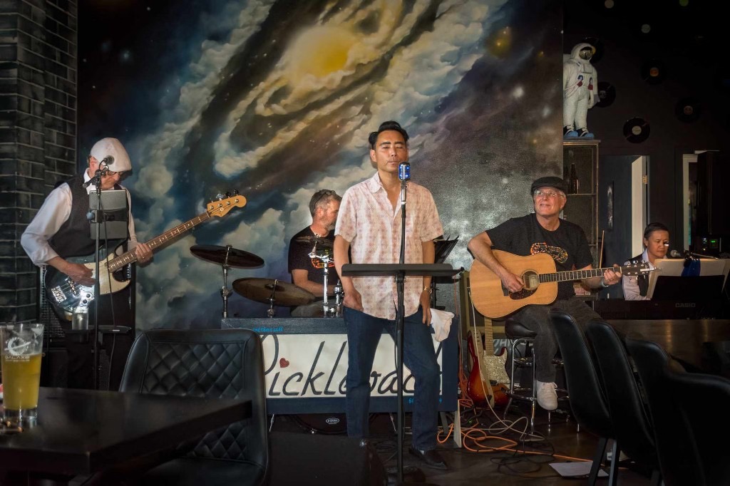 Pickleback performing live in front of a galaxy mural